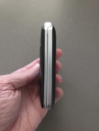 Protectly seniorentelefoon zijkant in hand, getest door nursepoint.nl